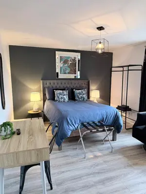 a bedroom with a blue bed and a table at No 19 Serviced Apartment in Ayr
