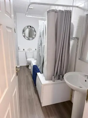 a white bathroom with a shower and a sink at No 19 Serviced Apartment in Ayr