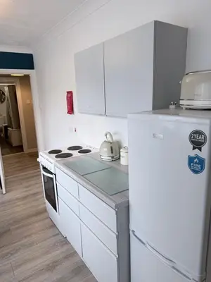 a white kitchen with a stove and a refrigerator at No 19 Serviced Apartment in Ayr