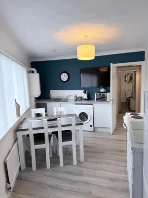 a kitchen with a table and chairs and a dining room at No 19 Serviced Apartment in Ayr