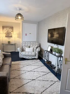 a living room with a couch and a flat screen tv at No 19 Serviced Apartment in Ayr