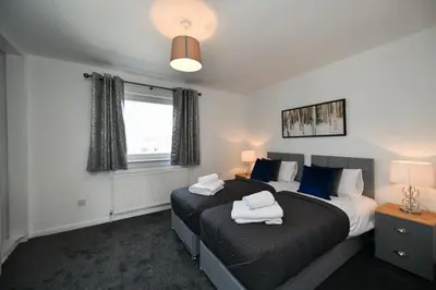 a bedroom with two beds and a window at Mews House in Ayr