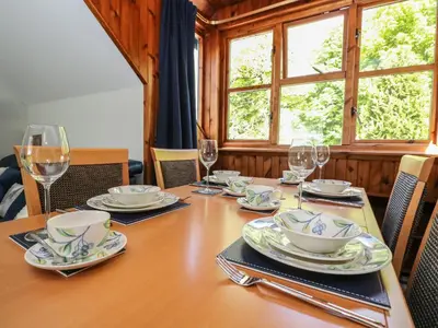 a wooden table with plates and glasses on it at Upper Brackendale in Taynuilt