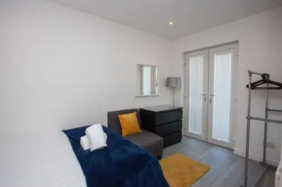 a living room with a bed and a chair at Southside Flat with Private Garden! in Glasgow