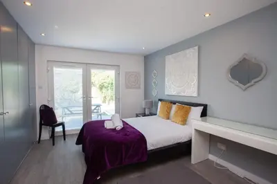a bedroom with a bed with a purple blanket at Southside Flat with Private Garden! in Glasgow