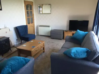 a living room with two couches and a television at Erradill Cottage in Southend