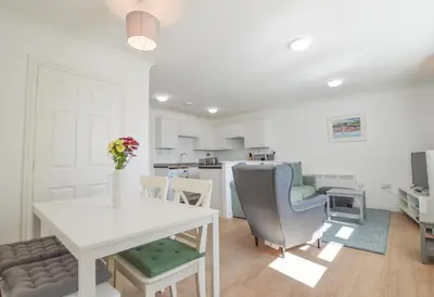a kitchen and living room with a table and chairs at No 8 Westbay Apartment in Oban