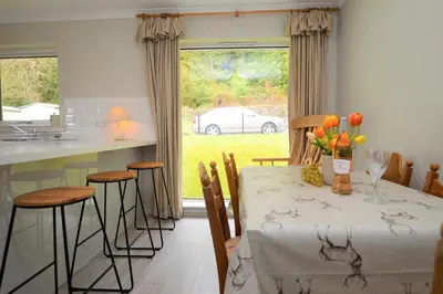 a kitchen and dining room with a table and chairs at Nursery Cottage in Kilmun