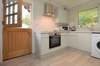 a kitchen with a sink and a stove top oven at Nursery Cottage in Kilmun