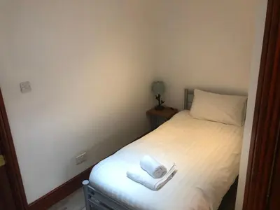 a bedroom with a bed with two towels on it at Ochiltree cottage in Newton Stewart