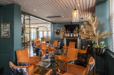 a restaurant with chairs and tables and a fireplace at The Kirkhouse Inn in Strathblane