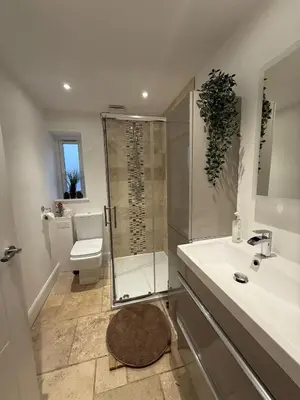 a bathroom with a shower and a toilet and a sink at Dreghorn House 5 b-rooms 9 beds 3 toilets 2 showers,1 bath 2 receiption Secure free Parking 233 Wifi in Edinburgh