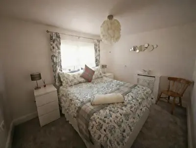 a bedroom with a bed and a window and a chair at Dreghorn House 5 b-rooms 9 beds 3 toilets 2 showers,1 bath 2 receiption Secure free Parking 233 Wifi in Edinburgh