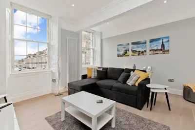 a living room with a couch and a table at Modern & Spacious 1 Bed Apt, West End in Edinburgh