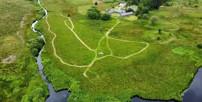 an aerial view of a field with a river at Anne's Cottage in Bargrennan