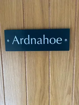 a blue sign on a wooden door with the word antidenride at Lochindaal Hotel in Port Charlotte