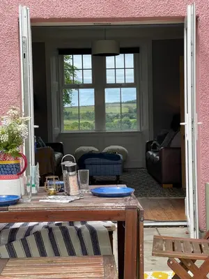 a living room with a table and a couch at Arran School House - Blackwaterfoot, Isle of Arran in Blackwaterfoot