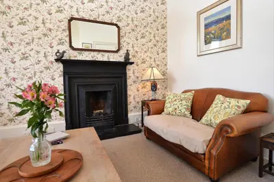 a living room with a couch and a fireplace at Kimberley Apartment in Dunoon