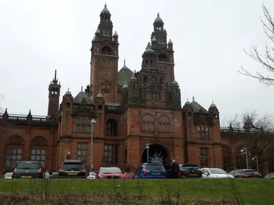 a large brick building with cars parked in front of it at Fabulous location, One Bedroom West End Flat, just off Byres rd, close to SEC & Hydro in Glasgow