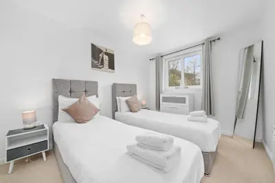 a bedroom with two beds and a window at Saughton Suite with views of Water of Leith in Edinburgh