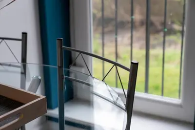a glass chair sitting in front of a window at Saughton Suite with views of Water of Leith in Edinburgh