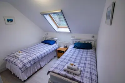 two beds in a attic bedroom with a window at Corran Bunkhouse in Onich