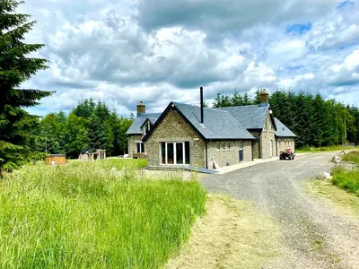 a house on a dirt road next to a field at The Lodge at Muir Estate in Thornhill