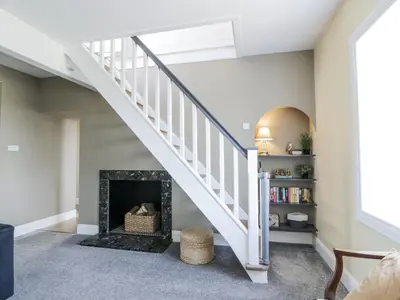 a living room with a fireplace and a staircase at Ailsa Shores in Turnberry