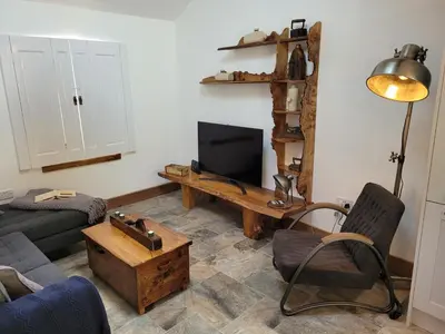 a living room with a couch and a tv at Loch Lomond Blair Byre in Rowardennan