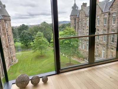 a room with a window looking out at a green yard at Quartermile Luxury Landing Apartment in Edinburgh