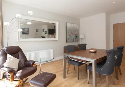 a dining room with a table and chairs and a mirror at Shandwick Apartment - Edinburgh City Centre - Sleeps 2 in Edinburgh