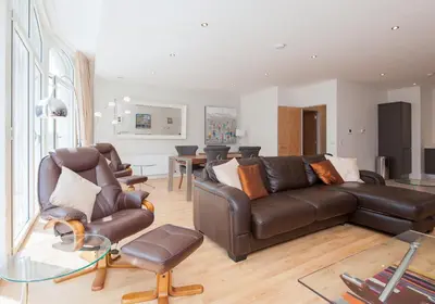 a living room with a leather couch and chairs at Shandwick Apartment - Edinburgh City Centre - Sleeps 2 in Edinburgh