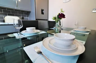 a table with a bowl and plates and a wine glass at Signature - Kirkhill Lower in Kirkmuirhill