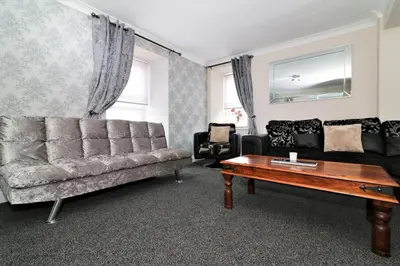a living room with a couch and a coffee table at Signature - Kirkhill Lower in Kirkmuirhill