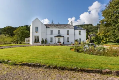 a large white house with a large yard at Killean Farmhouse B&B in Inveraray