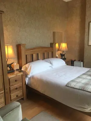 a bedroom with a large bed and two lamps on tables at Auchenlea bed and breakfast in Coatbridge