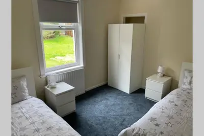 a bedroom with two beds and a window at Beautiful two bedroom flat by the Loch in Balloch