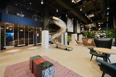 a lobby with a slide and chairs and tables at For Students Only Modern studios in Glasgow West End in Glasgow