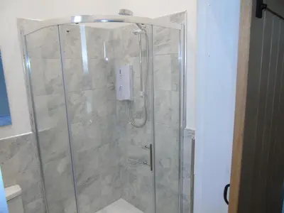 a bathroom with a shower with a glass door at Snug - Sealladh Mara Apartment in Helensburgh