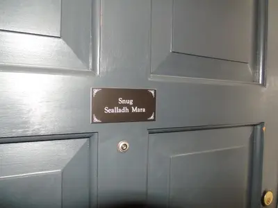 a close up of a door with a sign on it at Snug - Sealladh Mara Apartment in Helensburgh