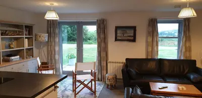 a living room with a couch and a kitchen with a window at One The Cairns in Connel