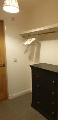a bedroom with a black dresser and a lamp at One The Cairns in Connel