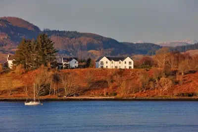 a house on a hill next to a body of water at One The Cairns in Connel