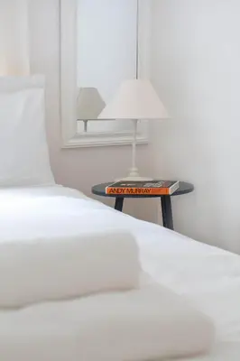 a bedroom with a bed and a table with a lamp at Stockbridge Two Bedroom Apartment in Edinburgh