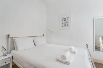 a bedroom with a white bed and a mirror at Stockbridge Two Bedroom Apartment in Edinburgh