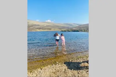 two girls walking in the water on the beach at Glendyne Cottages, Highest Village in Scotland in Wanlockhead