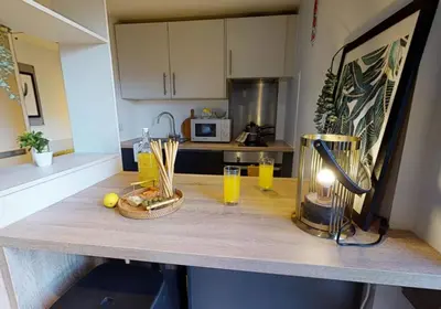 a kitchen counter with a table with glasses of orange juice at iQ Grove Accomodation in Edinburgh in Edinburgh