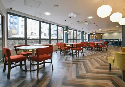a restaurant with tables and chairs and windows at iQ Grove Accomodation in Edinburgh in Edinburgh
