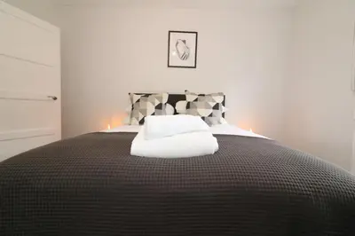 a bedroom with a bed with a white towel on it at Signature - Caldercruix House in Caldercruix