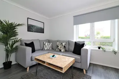a living room with a couch and a coffee table at Signature - Caldercruix House in Caldercruix